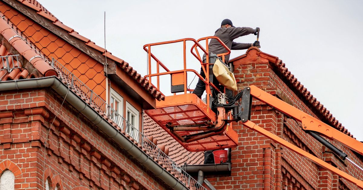 Un couvreur intervient sur une toiture en tuiles